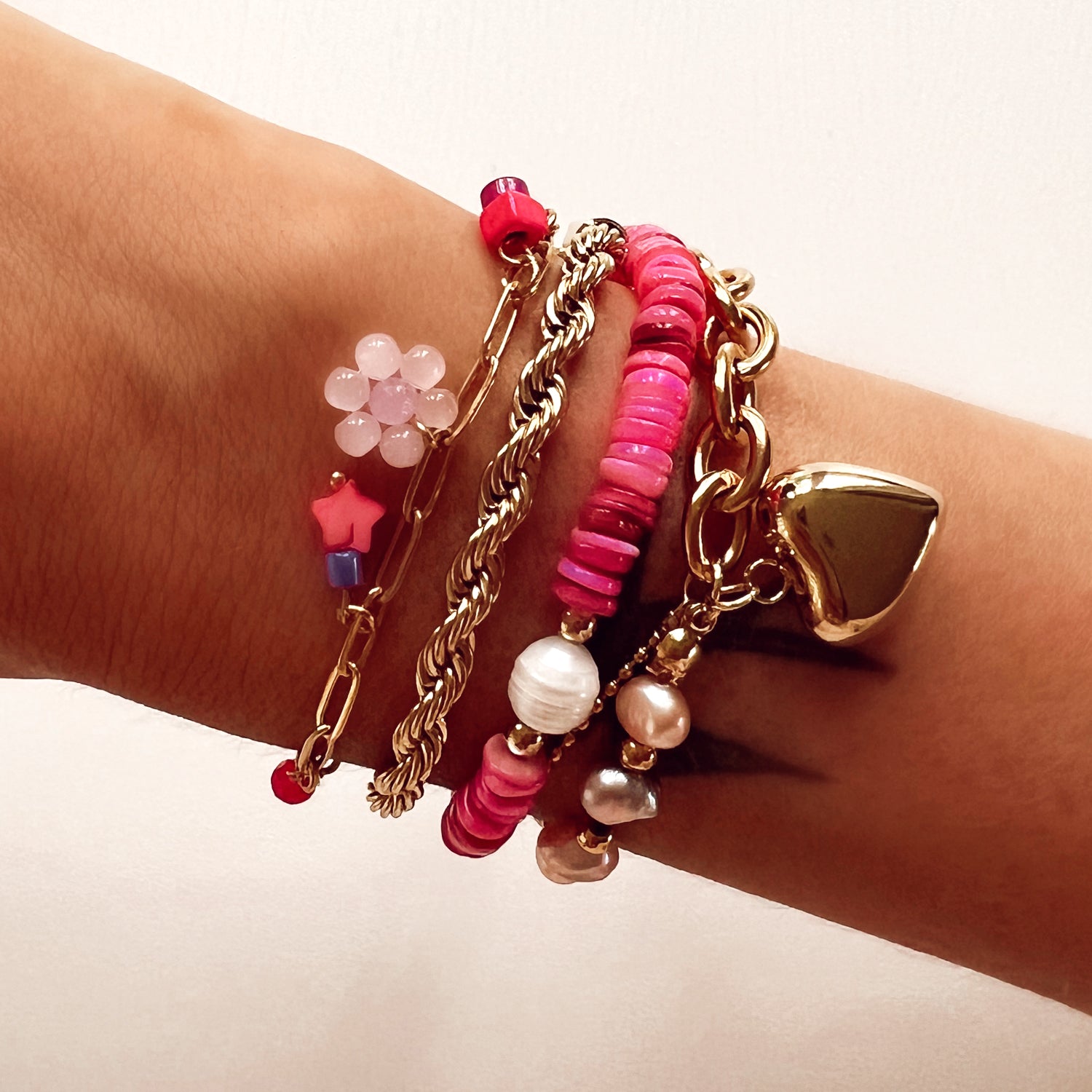 Gouden chain armband met fuchsia roze kralen en bloemetje. De armband is van roestvrij staal met een gold plated laagje en is waterproof.   Afmetingen 16 + 3 cm 