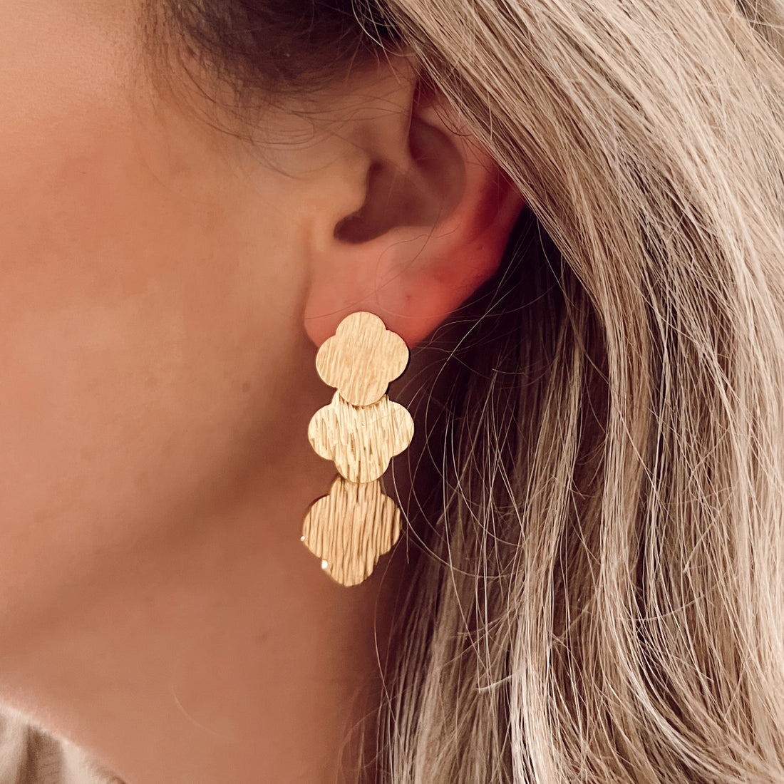Lange gouden oorbellen met klavertjes vier er aan. De oorbellen zijn van gold plated roestvrij staal materiaal en zijn waterproof.  Afmetingen 4 cm x 