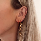 Chain oorbellen met gouden hart er aan. De oorbellen worden per paar verkocht en zijn gemaakt van roestvrij staal met een gold plated laagje. De oorbellen zijn waterproof.  Afmetingen: 5 cm