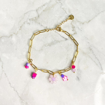 Gouden chain armband met fuchsia roze kralen en bloemetje. De armband is van roestvrij staal met een gold plated laagje en is waterproof.   Afmetingen 16 + 3 cm 
