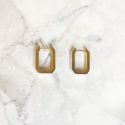 Gouden oorbellen in met gekartelde hoeken ingelegd met zirconia steentjes. De oorbellen zijn van gold plated stainless steel materiaal en zijn waterproof. Cubic zircon earrings gold. 