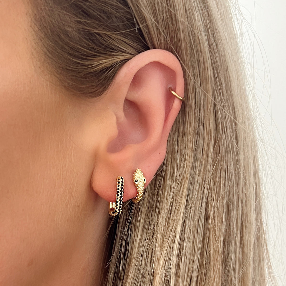 Kleine oorbellen goud in de vorm van slang met zwart oogje. De oorbellen zijn van gold plated koper materiaal en zijn waterproof. Snake earrings hoops gold. 